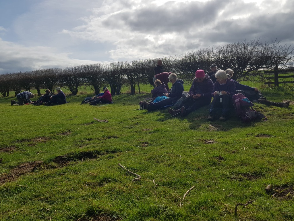Walkers sitting having their lunch on a grassy bank